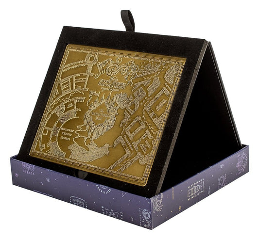 Carte du Maraudeur Harry Potter en métal doré embossé, présentée sur son support noir, avec détails de Poudlard et traces de pas en relief.