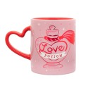 Mug Amortentia Harry Potter rose avec anse rouge en forme de cœur et motif philtre d’amour.