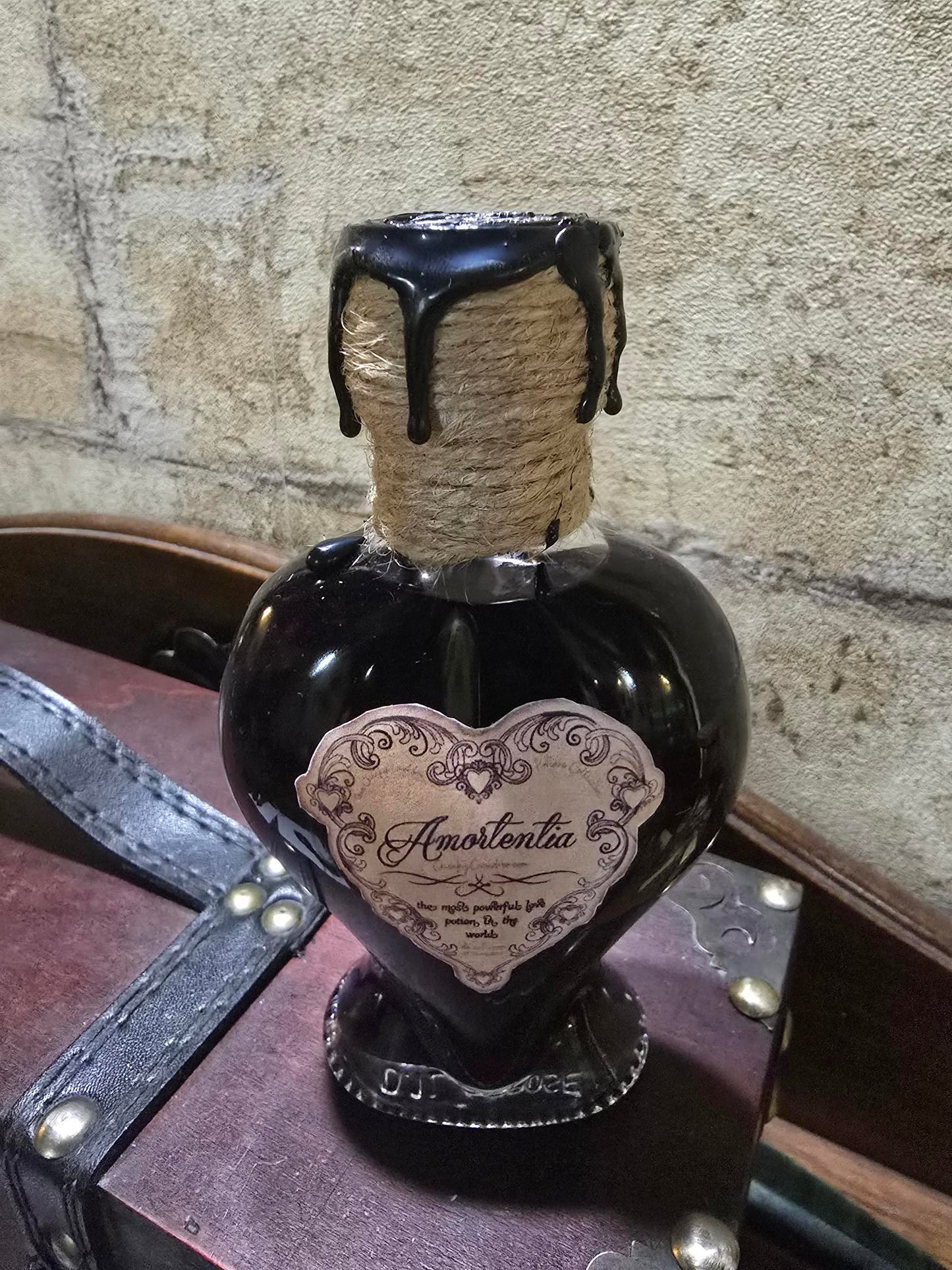 Potion Amortentia dans un flacon en forme de cœur, scellée à la cire artisanale, avec effet de couleur changeant.