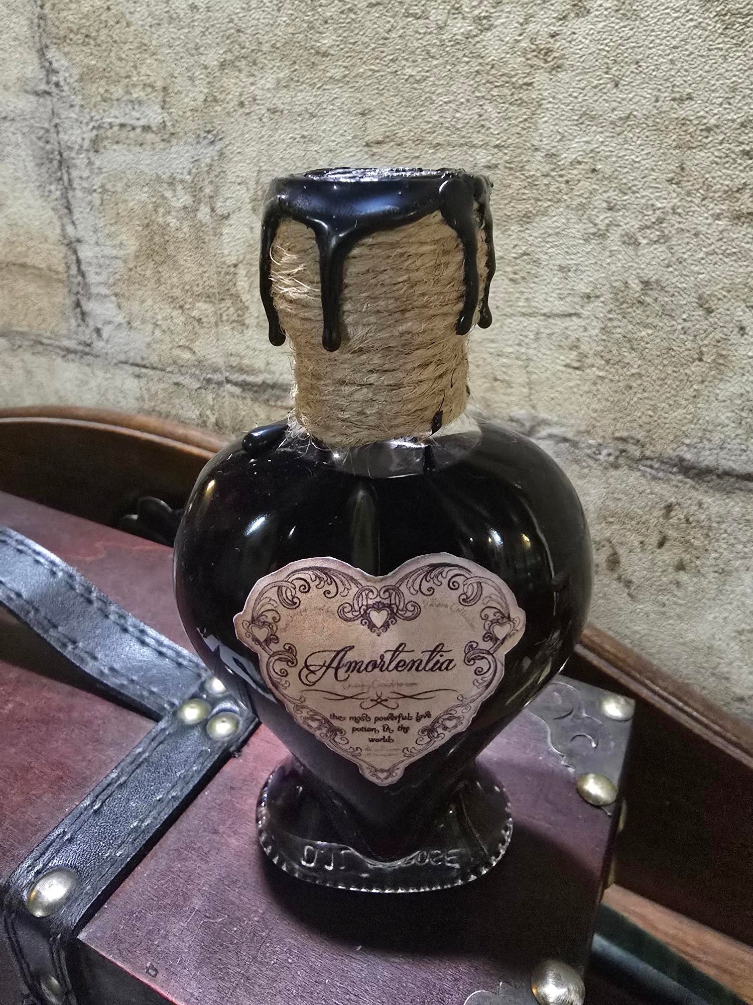 Potion Amortentia dans un flacon en forme de cœur, scellée à la cire artisanale, avec effet de couleur changeant.