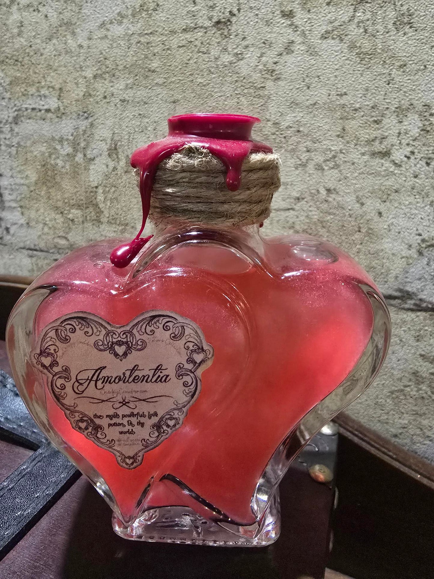 Potion Amortentia dans un flacon double cœur en verre, scellée à la cire artisanale.